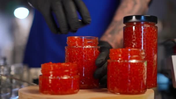 Frascos Caviar Vermelho Close Com Copos Masculinos Mão Rolando Cozinheiro — Vídeo de Stock