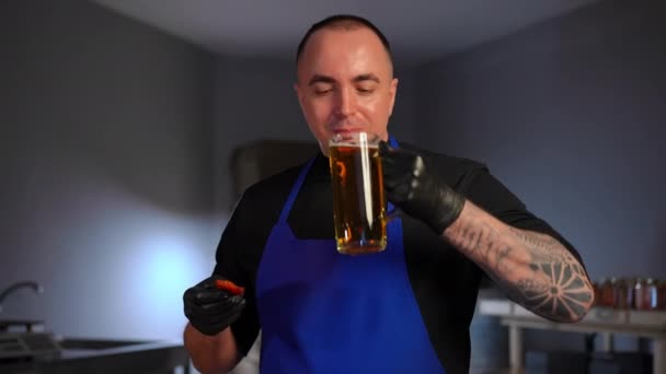 Tetovált Férfi Sört Iszik Füstölt Halat Eszik Miközben Kamerát Nézi — Stock videók