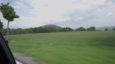 Orman ve dağların arkasındaki yaprakları döken ağaçlardan geçen arabaların şahsi görüntüsü. Avrupa 'da seyahatler açık havada tatiller