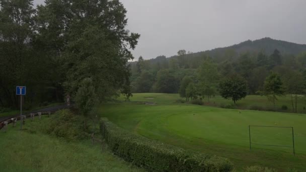屋外の曇りの雨の日に木や山の丘で広いショット緑の牧草地 雲の上の美しいヨーロッパの自然秋の夏 — ストック動画