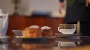 Yakın plan çay ve bulanık Müslüman adamın kahvaltıdan önce dua ederek eve girdiği tatlı bir tatlı. Tanınmayan genç dindar bir adam Allah 'a içeride yemek ve içecek için teşekkür ediyor.