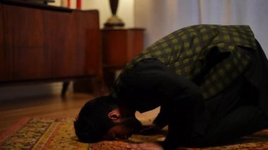 Yandan bakıldığında, Müslüman genç adam oturmuş konuşuyor. Canlı kamera, evde Ramazan 'a dua eden yakışıklı, kendine güvenen, konsantre bir inanana odaklan.