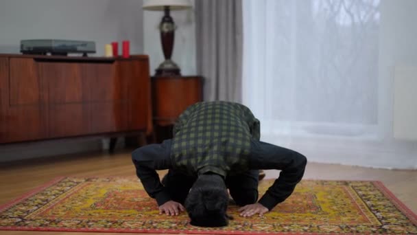 年轻的穆斯林男子在家里向真主鞠躬祈祷 漂亮的中东男性信徒在斋月仪式上的全景画像 — 图库视频影像