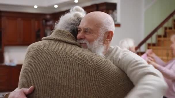 快乐的白种人笑容满面的年长男人拥抱着模糊的女人 在背后拥抱 快乐的老朋友们在室内迎接 — 图库视频影像