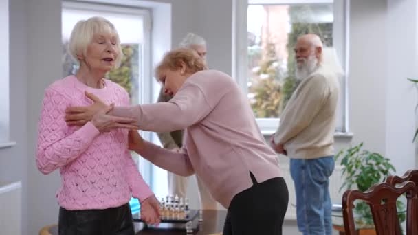 Positive Seniorinnen Prahlen Mit Neuen Klamotten Während Verschwommene Männer Hintergrund — Stockvideo