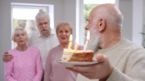 Der Bärtige Alte Kaukasische Lächelnde Mann Bläst Kerzen Auf Dem — Stockvideo