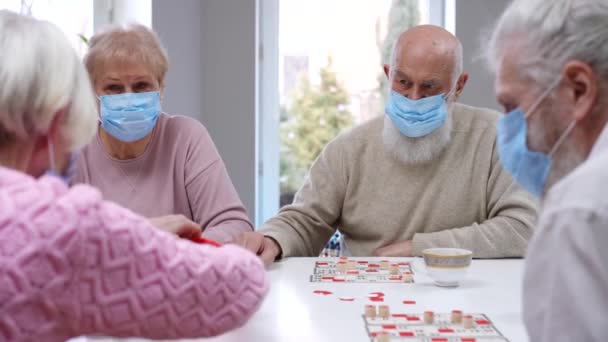 Grupo Ancianos Positivos Amigos Caucásicos Coronavirus Mascarillas Jugando Mesa Lotería — Vídeo de stock