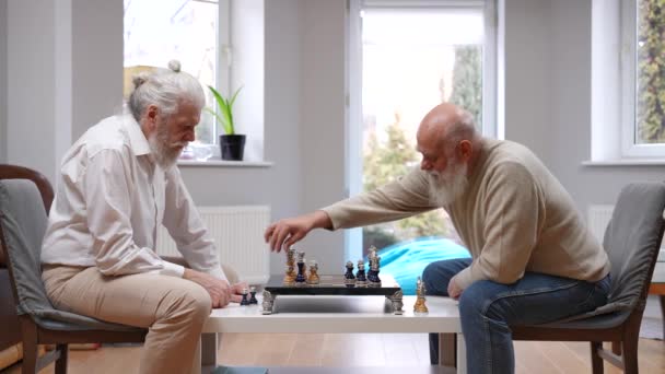 聪明的白人老人和老朋友握手赢得了国际象棋的胜利 快乐悠闲的退休人士在室内游戏的侧景肖像 — 图库视频影像