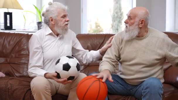 Viejo Amigo Caucásico Discutiendo Sobre Fútbol Baloncesto Sentado Sofá Sala — Vídeo de stock