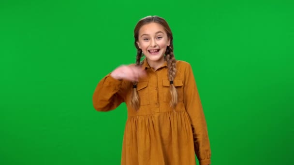 一个积极迷人的女孩微笑着看着摄像机 站在绿色屏幕的背景上 在色键前摆姿势的快乐快乐的白人青少年的中景肖像 — 图库视频影像