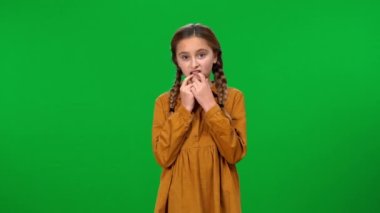 Tırnak yiyen sinirli genç kız yeşil ekran arka plan görüntüsüne bakıyor. Tereddüt eden beyaz bir gencin orta boy portresi.