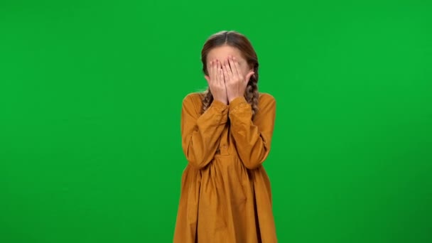 恐惧的女孩双手捂住脸看着摄像机站在彩色键的背景上 害怕的白人青少年在绿色屏幕上摆出恐惧和恐惧的形象 — 图库视频影像