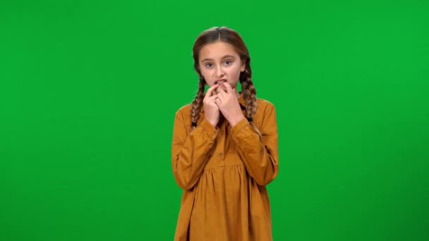 神经质的少女咬着钉子看着摄像机的绿色屏幕背景前视图 摇摆不定的高加索少年在彩色键上的中景肖像画 — 图库视频影像