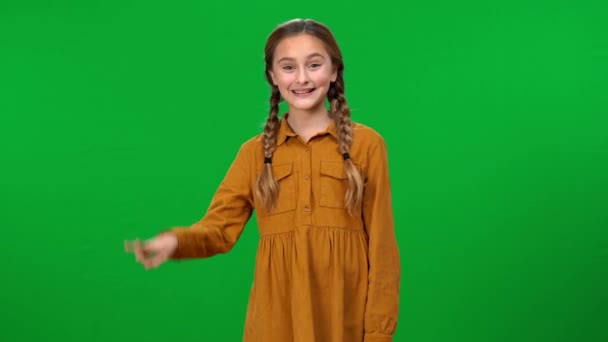 笑容满面的女孩露出和平的姿态 看着站在绿屏前的相机 乐观而自信的白人青少年在色键上做广告的形象 — 图库视频影像