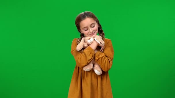 快乐的少年黑发女孩与小辫子玩玩具兔子笑在绿色屏幕上 满足的 自信的 轻松的白人青少年在色域背景下享受闲暇的画像 — 图库视频影像