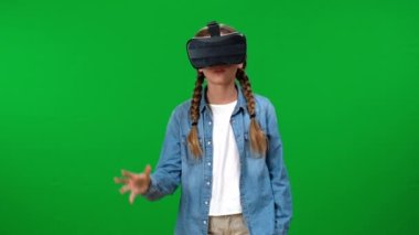 İnternet üzerinden oyun oynayan Kafkasyalı kız gözlüğünü çıkartıyor, gülümsüyor ve işaret ediyor. Yeşil ekranda poz veren heyecanlı genç portresi