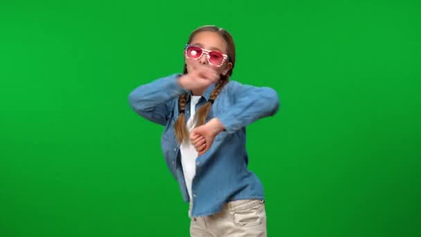 快乐的年轻白人女孩戴着太阳镜 在色彩斑斓的背景下跳舞 面带微笑 兴奋快乐的青少年在绿屏上享受休闲的画像 — 图库视频影像
