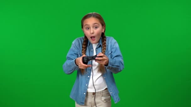 吸引住了兴奋的少女在绿屏背景下玩着游戏板操纵杆 色键上满足的白人青少年快乐游戏的肖像 — 图库视频影像