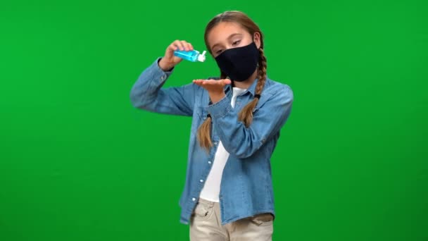 身穿考罗纳威面罩的少女用清洁剂消毒双手 看着镜头笑着 在Covid 19大流行病的绿屏背景下呈阳性 自信的白人青少年 — 图库视频影像
