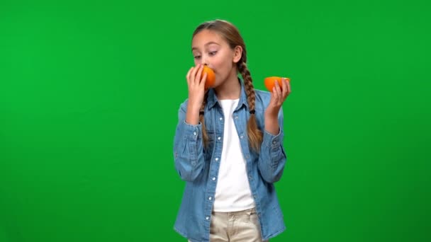 Веселая Девочка Подросток Лижет Половинки Вкусного Витаминного Апельсина Улыбаясь Глядя — стоковое видео