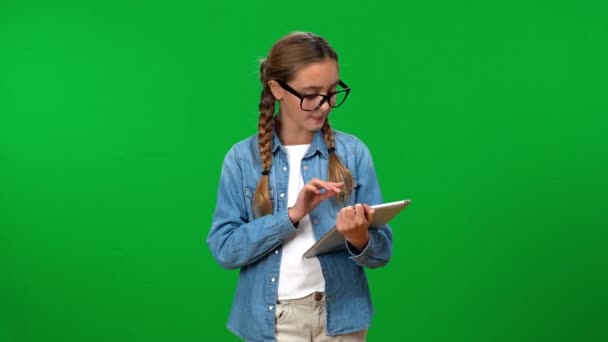 聪明聪明的少女卷动着数字平板电脑 面带微笑地看着相机 给人一种惊讶的表情 把大拇指抬起来 自信的白人青少年在绿屏上摆姿势 — 图库视频影像