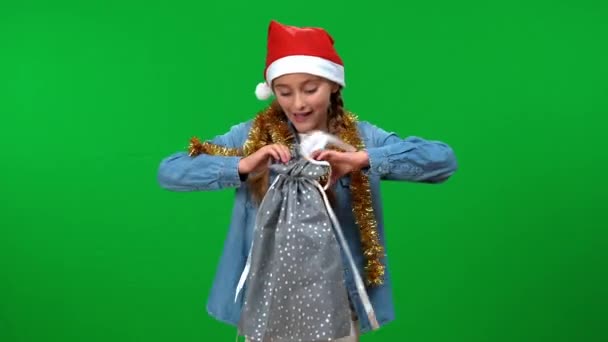 除夕之夜 一个快乐的白人少女在袋中看礼物的画像 在圣诞节的绿屏背景上 兴奋地微笑着的青少年 — 图库视频影像