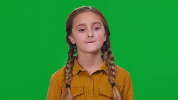 茶色の目をしたブルネットの女の子は 緑の画面上のカメラを見て無力ジェスチャーをジェスチャー考えている フロントビュークローズアップのコーカサスティーンポルノの表現できません変更感情 — ストック動画