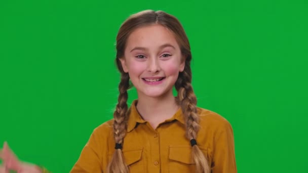 一个积极漂亮的女孩 双手微笑着在绿色的屏幕上看着相机 表现出和平的姿态 彩色背景下自信的高加索少年的特写 令人欣喜 — 图库视频影像