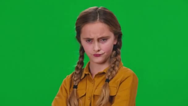 クローズアップ不満顔の表情で緑の画面に背を向ける未成年の少女 クロマキーの背景に不満を表現する白人のティーンエイジャーのクローズアップ肖像 — ストック動画