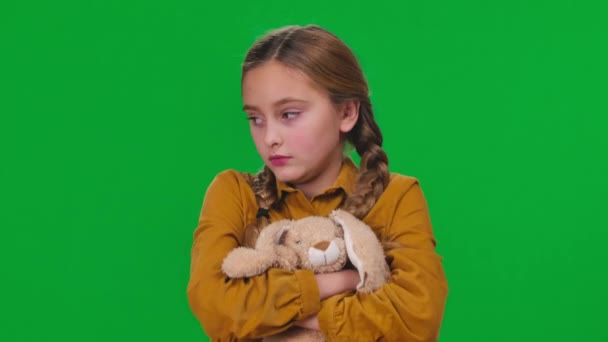 特写不满意的女孩与玩具看相机与顽固的面部表情在绿色屏幕上 高加索灰心丧气的青少年在彩色背景下的前视特写 — 图库视频影像