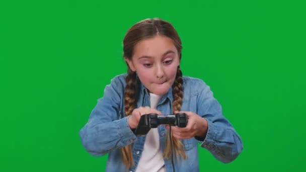 自信满腔热忱的女孩在绿色屏幕上玩着游戏游戏 游戏的操纵杆上挂着绿色的表情 白人青少年在背景下享受电子游戏的肖像 — 图库视频影像