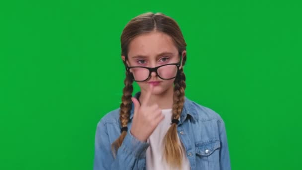 认真聪明的女孩调整眼镜在鼻子上看相机在绿色屏幕上 彩色背景下自信聪明的书呆子白人青少年的前视图画像 — 图库视频影像