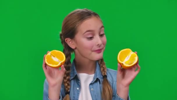 Close Linda Chica Encantadora Haciendo Caras Que Muestran Mitades Naranja — Vídeos de Stock