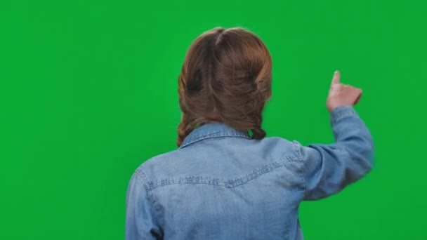 后视镜黑发女孩在牛仔衬衫使用网络现实在绿色屏幕移动的手 白人青少年在彩色背景下享受着更大的实景 — 图库视频影像