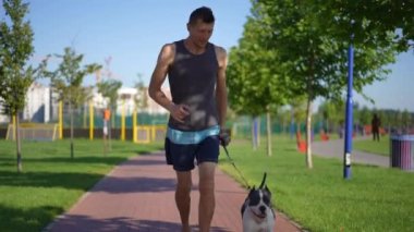 Dolly, kendinden emin sporcunun yavaş çekimde köpekle koşup evcil hayvanı okşamasını durduran portresi. Ön cephedeki beyaz adam Amerikan Staffordshire Teriyerini okşayarak antrenman yapıyor.
