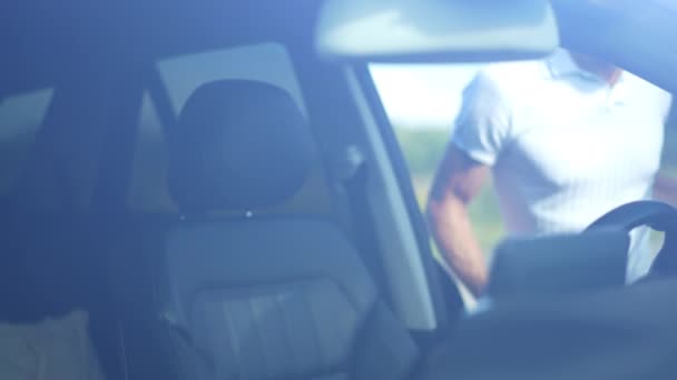 在阳光灿烂的日子里 一个自信的男人从挡风玻璃中冲出 满意的英俊白人司机坐在司机座位上笑着 — 图库视频影像