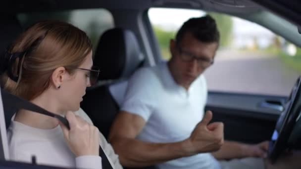 全神贯注的年轻漂亮女人紧紧抓住安全带 就像坐在驾驶座上说话的模糊男人 坐在汽车上与丈夫聊天的专注的白人妻子的侧角肖像 — 图库视频影像