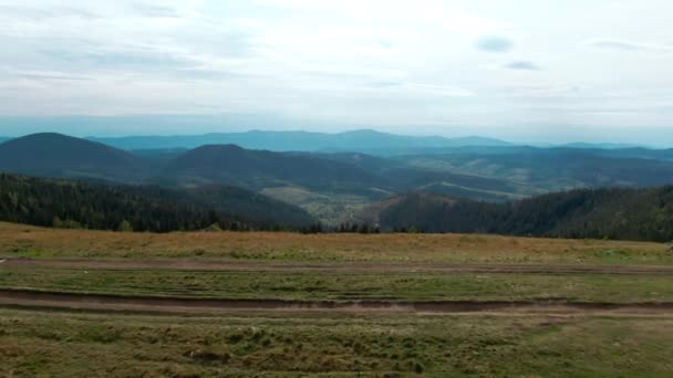 现场摄象机沿着山顶向前移动 背景是蓝色喀尔巴阡山脉 户外阴郁的早晨 鸟瞰广袤如画的风景 — 图库视频影像