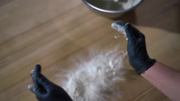 高角镜下 女性手戴手套 将白粉铺在木制桌子上 无法辨认的白人妇女正在准备室内烘焙的配料 — 图库视频影像