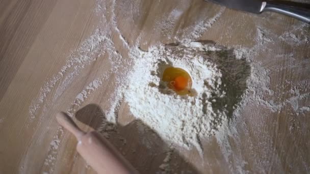 顶部的生鸡蛋在白色面粉与滚动针在木制桌面上 厨房室内的特写烘烤配料和餐具工具 — 图库视频影像