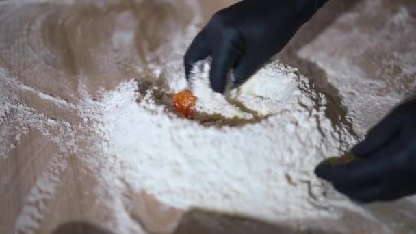 在室内的木制桌子上 把面粉和鸡蛋混合在一起 无法辨认的女厨师戴着手套在厨房烘焙美味食物中混合配料 — 图库视频影像