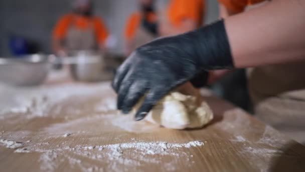 サイドビューレストランキッチン内のスローモーションで生地を混練認識できない女性が屋内 カフェで食材を調理する白人女性のパン職人 — ストック動画