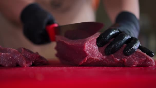 レストランのキッチンでナイフで肉汁の入った赤肉をクローズアップ 閉鎖認識できない白人女性で手袋準備ミートローフスライス食品でスローモーション — ストック動画