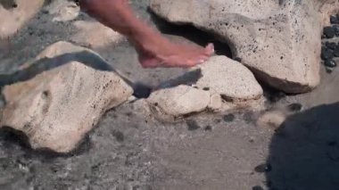 Akdeniz 'de güneş ışığındaki kayaların yakınındaki ince bronzlaşmış kadın bacakları ayrılıyordu. Kıbrıs 'ta güneşli bir günde okyanustan çıkan tanınmamış beyaz kadın