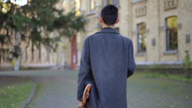 Üniversitenin girişine ağır çekimde yürüyen kaykaylı, kendinden emin beyaz bir adamın kameraya gülümseyişini izliyorum. Mutlu öğrenci dışarıda poz veriyor.