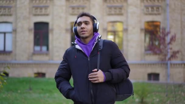 Mladý Usměvavý Muž Sluchátkách Který Chodí Univerzitu Poslouchá Hudbu Portrét — Stock video