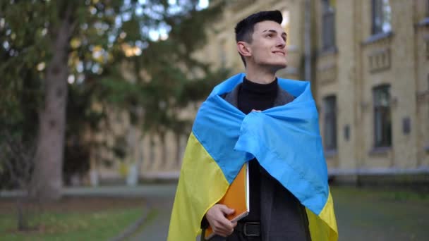 Joven Envuelto Bandera Ucraniana Mirando Alrededor Mirando Cámara Sonriendo Feliz — Vídeo de stock