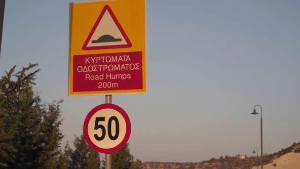 クローズアップ道路ハンプと左にライブカメラのパンニング右と50速度制限記号 キプロスのギリシャ語と英語の交通標識を屋外で閉鎖 — ストック動画