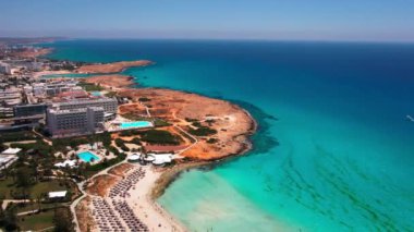 Kıbrıs 'taki Akdeniz' de gökyüzü mavisi renginin hava görüntüsü. Geniş açı, sakin deniz manzarası, açık havada güneş ışığı.