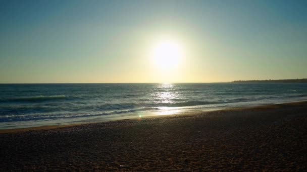 波がスローモーションで砂浜に転がり 地中海の上に絵のように美しい夕日を撮影しました キプロスの太陽の光 屋外の観光リゾート — ストック動画